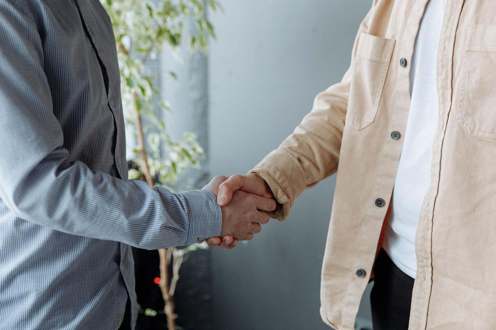 Twee mensen geven elkaar de hand als teken van vertrouwen en samenwerking